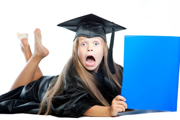 Linda niña en vestido de graduación con libro azul en blanco aislado —  Fotos de Stock