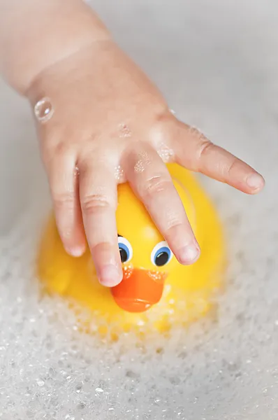 Kleinkind badet mit einer Gummiente — Stockfoto