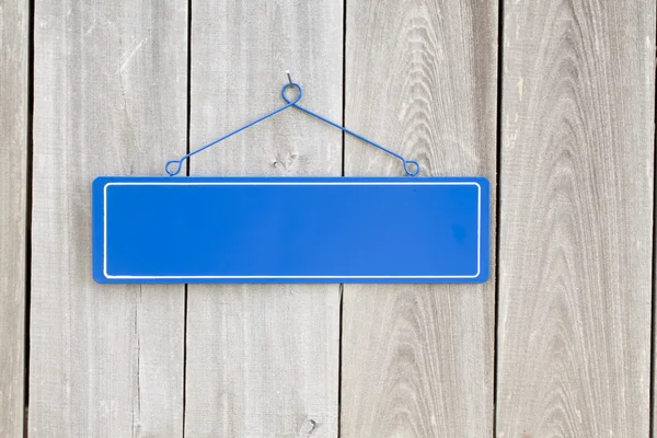 Placa azul em branco na velha cerca de madeira rústica — Fotografia de Stock