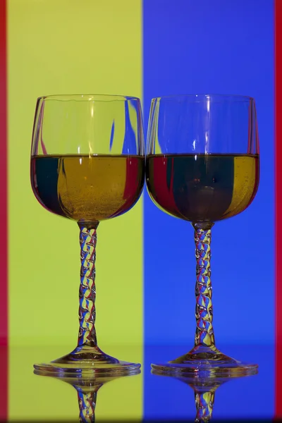 カラフルな背景を持つ 2 つのワイングラス — ストック写真