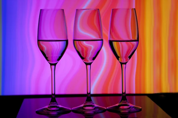 Três copos de vinho com fundo colorido — Fotografia de Stock
