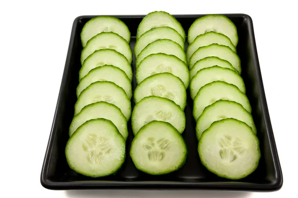 Sliced cucumber on a black plate — Stock Photo, Image