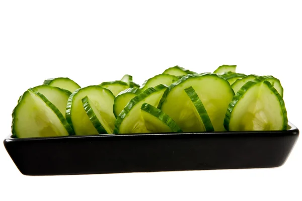 Sliced cucumber stacked on a black plate — Stock Photo, Image