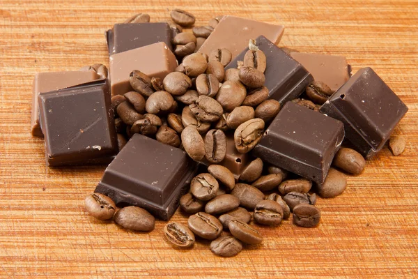 लकड़ी की प्लेट पर चॉकलेट और कॉफी बीन्स — स्टॉक फ़ोटो, इमेज