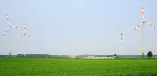 Windmills in the field and a tractor in the middle — Stock Photo, Image
