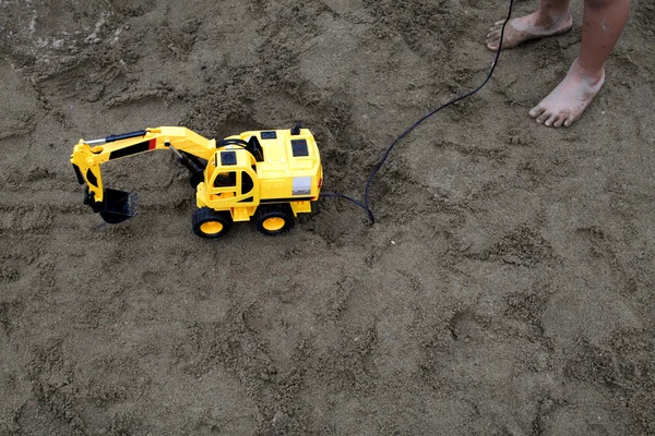Dzieci bawiące się na plaży zdalnego pojazdów inżynieryjnych — Zdjęcie stockowe