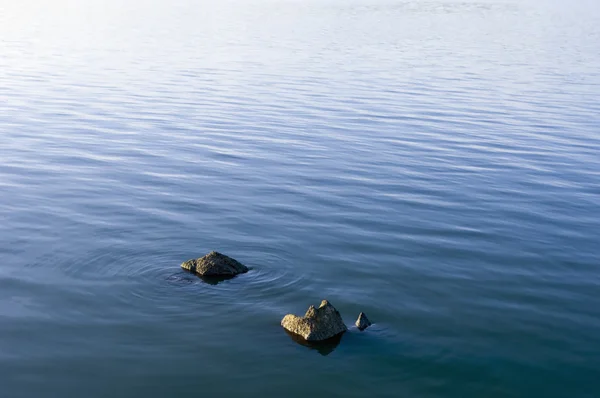 Pedras na superfície da água — Fotografia de Stock