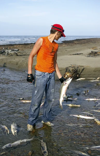 Парень с лососем в руке — стоковое фото