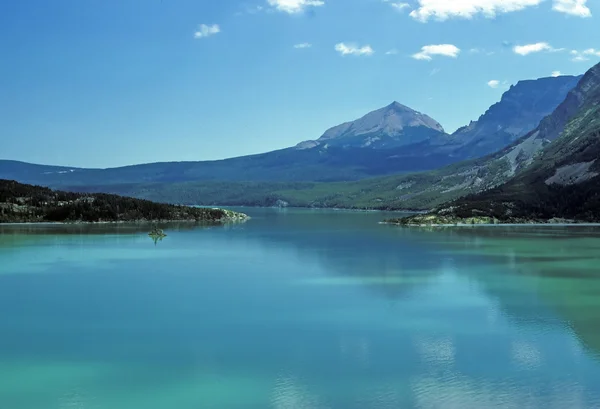 Una vetta solitaria con un lago alpino — Foto Stock