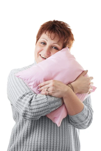 Счастливая женщина обнимает розовую подушку — стоковое фото