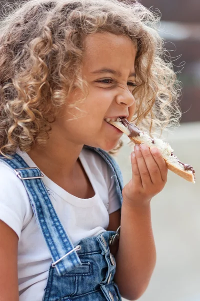 Маленькая девочка и кусок хлеба — стоковое фото