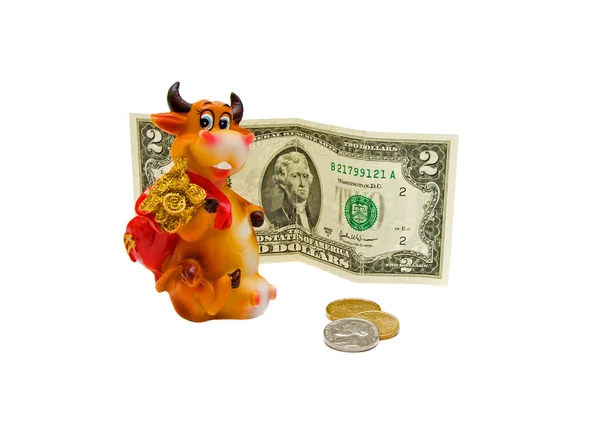 Spielzeugkuh, Münzen und Geldscheine auf weißem Hintergrund. — Stockfoto