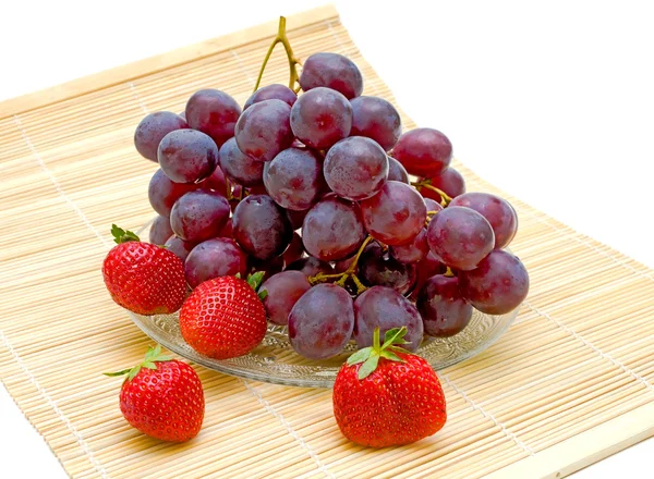 Druiven en aardbeien op een witte achtergrond — Stockfoto