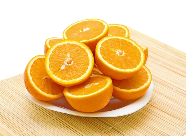 Стиглі апельсини розрізані навпіл лежать на тарілці — стокове фото