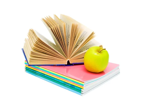 Offenes Buch, ein Stapel Notizbücher und ein Apfel. — Stockfoto
