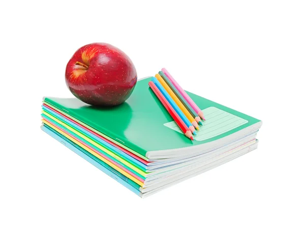 Блокноти, олівці та яблуко — стокове фото