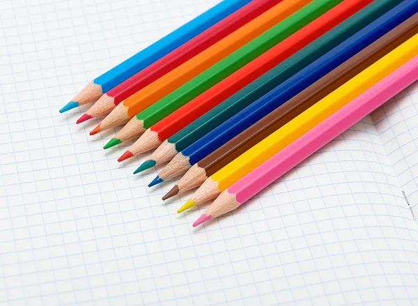 Lápis coloridos em um caderno aberto — Fotografia de Stock