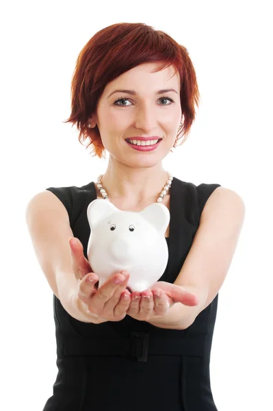 Woman holding piggy bank against white background — Stockfoto
