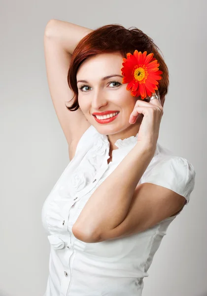 Vacker kvinna med blomma gerbera i hennes händer mot vita b — Stockfoto
