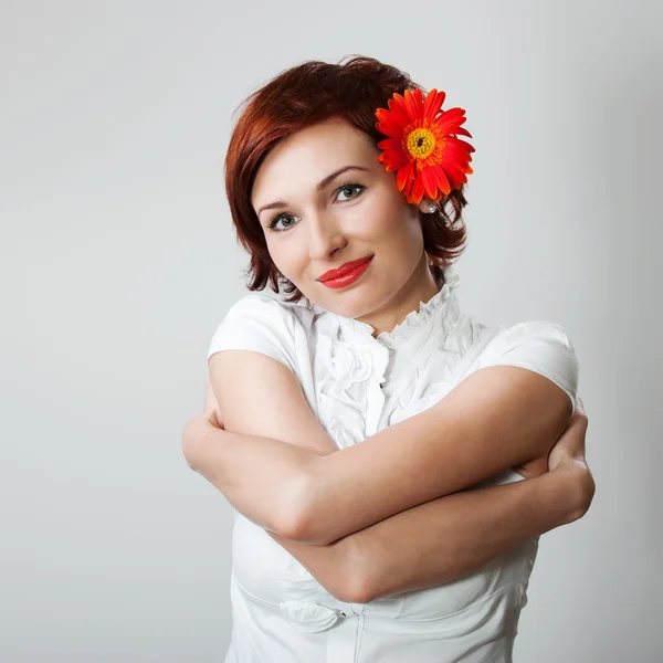 Vacker kvinna med blomma gerbera mot vit bakgrund — Stockfoto