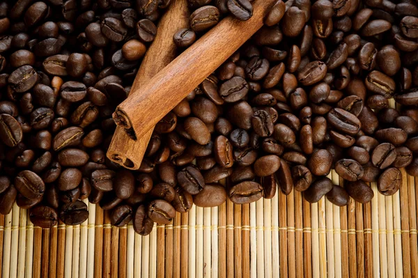 Горстка ароматных кофейных зерен с корицей — стоковое фото