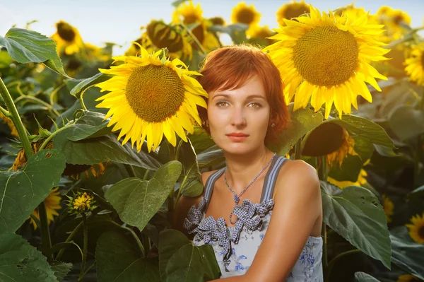 Frau auf blühendem Sonnenblumenfeld — Stockfoto