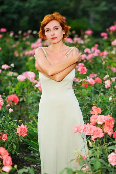 Woman in a garden of roses — Stock Photo, Image