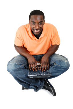 Young student sitting and using his laptop clipart