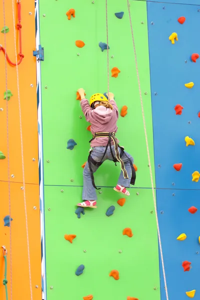 Bambino che si arrampica su una parete da arrampicata, all'aperto — Foto Stock