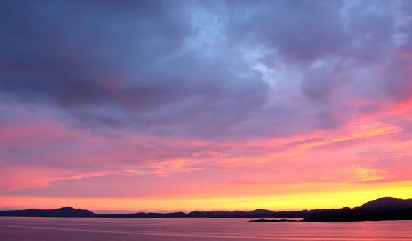 Панорамою заходу сонця з човні від узбережжя Норвегії — стокове фото