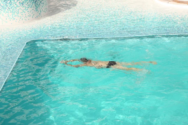 Homem nadando na água azul da piscina — Fotografia de Stock