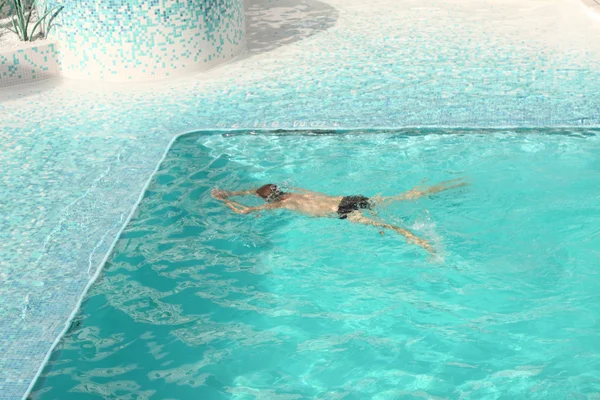 Człowiek pływanie w niebieski wody w basenie — Zdjęcie stockowe