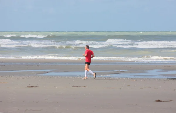 Homem correndo na praia verão ensolarado — Fotografia de Stock