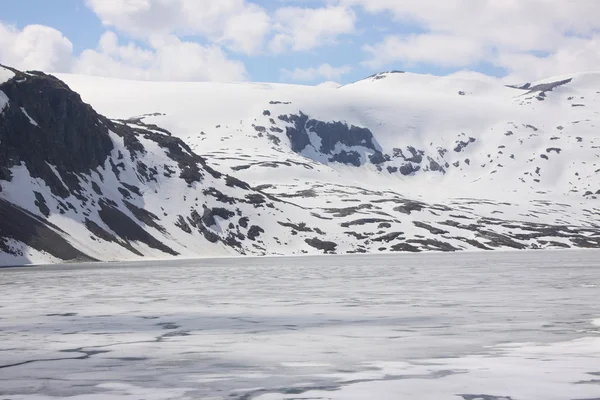 Zamarznięte jezioro i ośnieżonych szczytów górskich w Norwegii — Zdjęcie stockowe