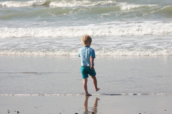 stock image Young child walking on the sand to the waves