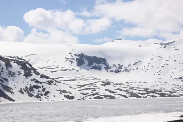 Zamrzlé jezero a zasněžené hory v Norsku — Stock fotografie