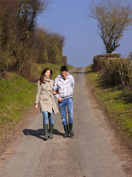 Couple of young walking in the campaign in spring — Stock Photo, Image