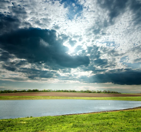 Vista para a paisagem nublada com lagoa — Fotografia de Stock