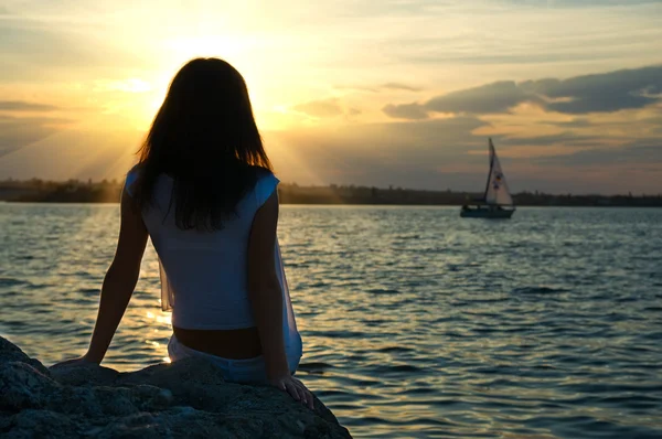 Su kenarında oturan kız — Stok fotoğraf