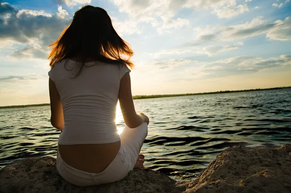 Girl meditations near water — Stock Photo, Image