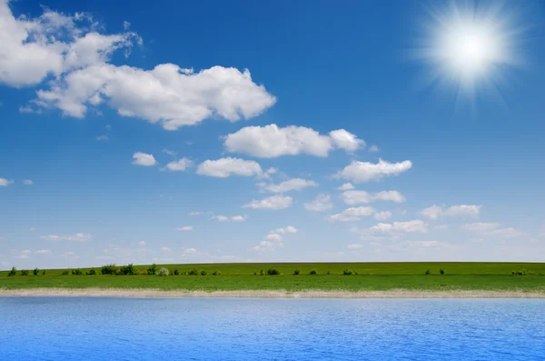 Rivier met bewolkte hemel en zon — Stockfoto