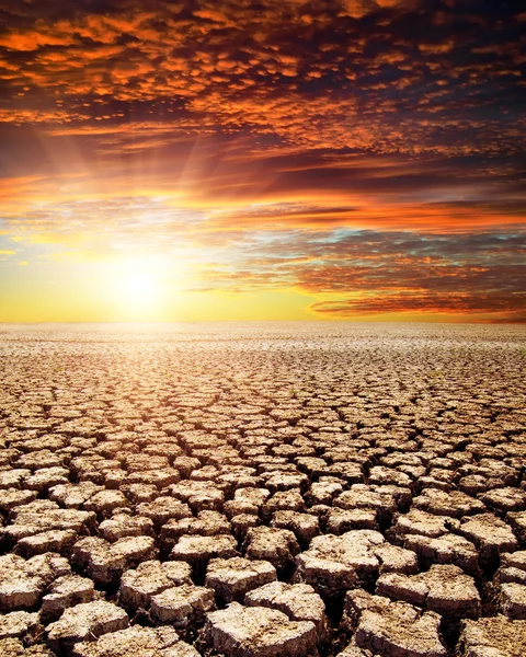 Kuraklık toprak altında kırmızı günbatımı — Stok fotoğraf