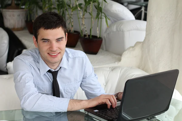 业务的人。英俊的年轻男孩，用在室内的笔记本电脑 — 图库照片