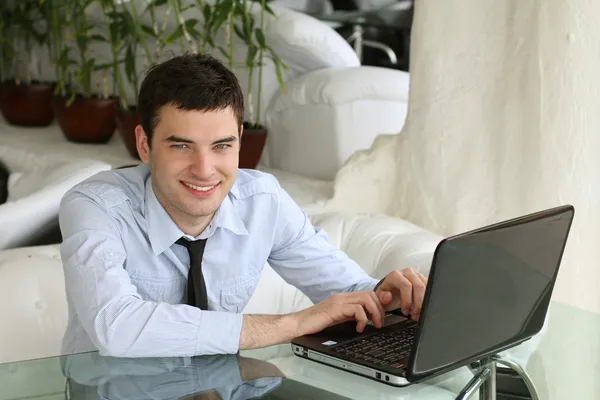 英俊的笑脸男人用的笔记本电脑。洁白的牙齿。商人。端口 — 图库照片