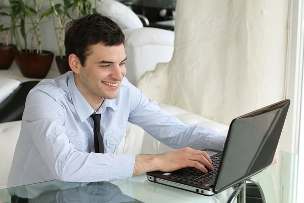 Uśmiechający się młodych ludzi pracy na laptopie. miejscu pracy. garnitur w salonie. h — Zdjęcie stockowe