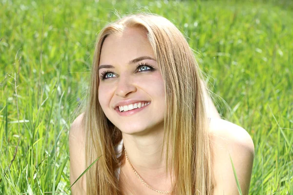Smiling beautyful young girl on nature field background — Stock Photo, Image