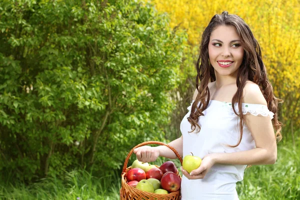 Szczęśliwa młoda kobieta z jabłek w koszyku. wiosna w ogrodzie — Zdjęcie stockowe