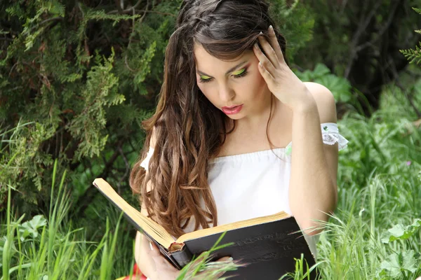 Молода красива дівчина читає книжку на природі. відкритий — стокове фото