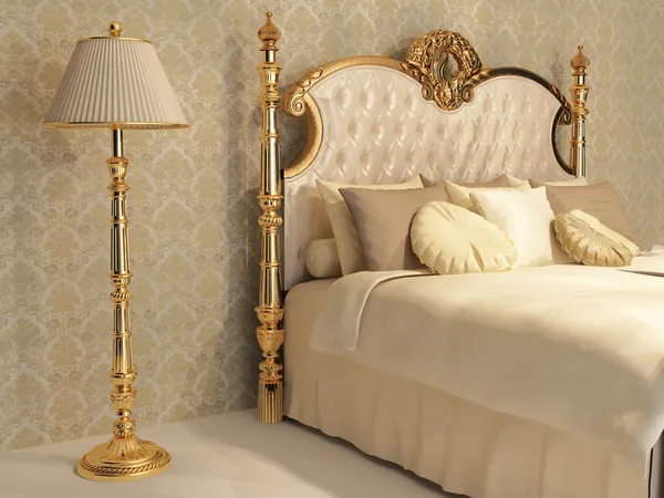 Cama luxuosa com moldura dourada e candeeiro de pé no quarto real — Fotografia de Stock