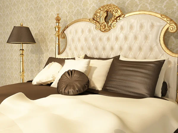 Lujosa cama con almohadas y lámpara de pie en el interior real —  Fotos de Stock